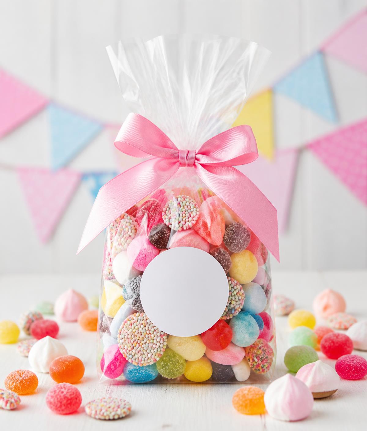 Clear pick n mix sweet bag tied with a pink ribbon and a round sticker label